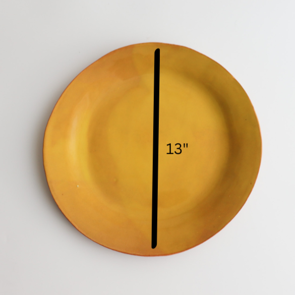 yellow ceramic plate showing thirteen inch diameter measurement on a white background