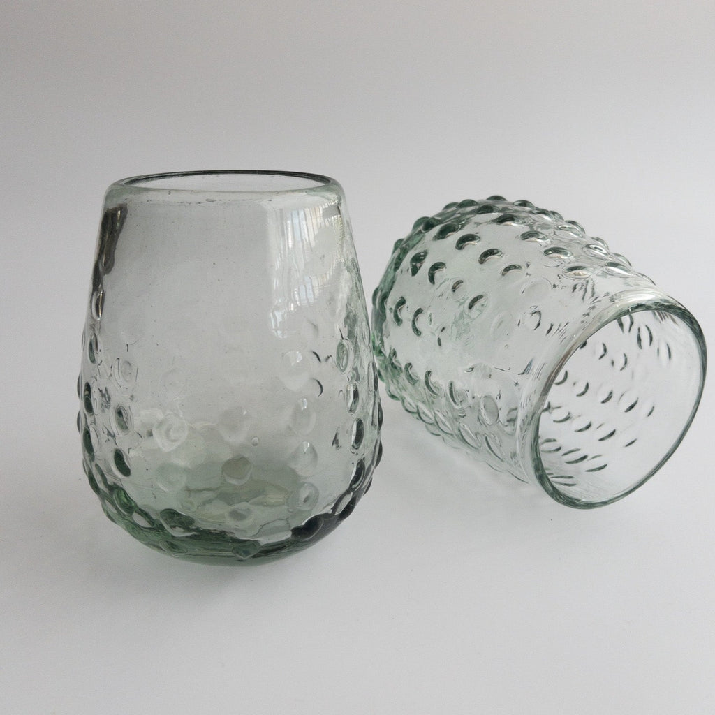 Studio CM | two round glass tumblers that are handblown with glass dots adorning the exterior