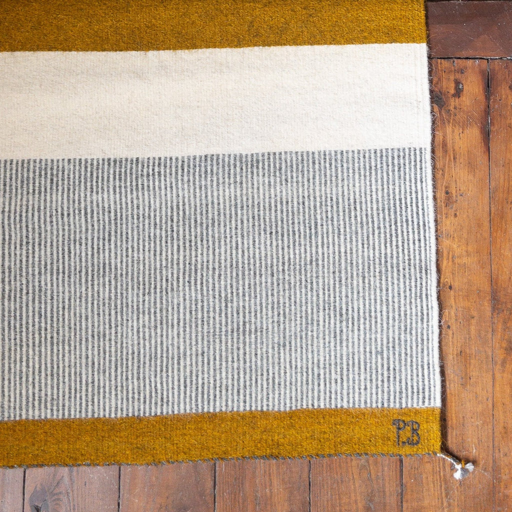 Studio CM | a beautiful hand made Zapotec rug made with a rich mustard yellow, cream and gray linear designs