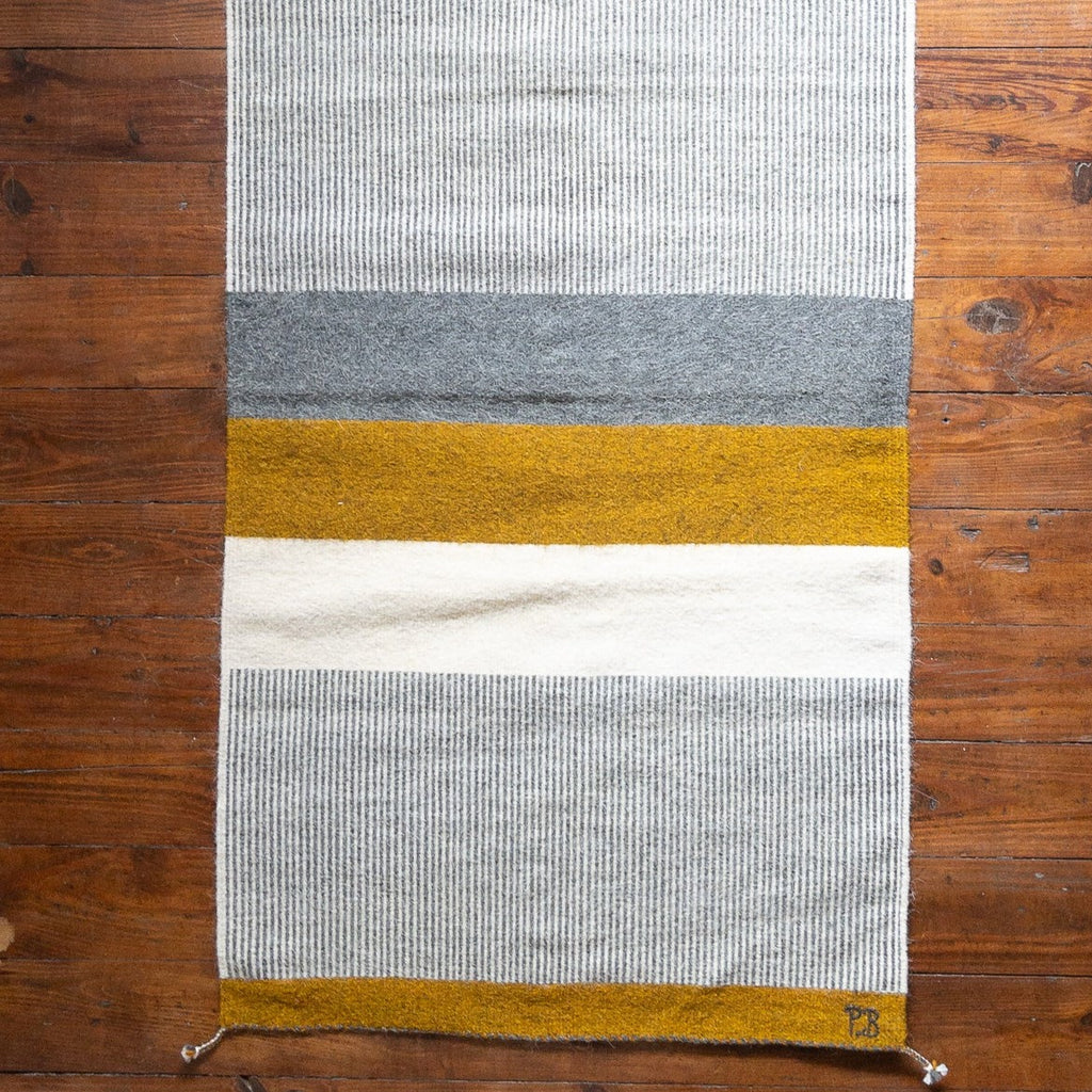 Studio CM | a beautiful hand made Zapotec rug made with a rich mustard yellow, cream and gray linear designs