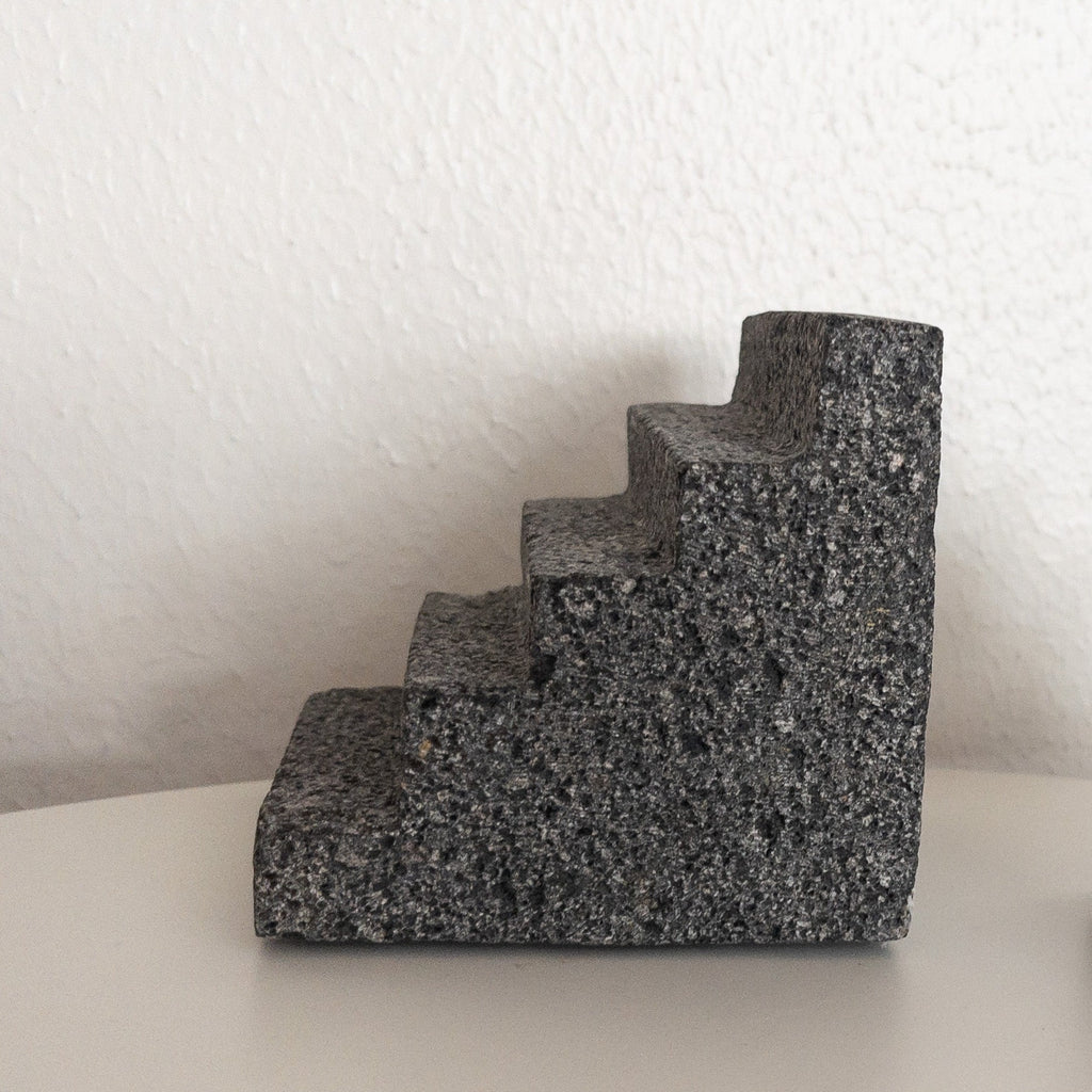 Studio CM | bookend in the shape of a Pyramid made of volcanic stone with a porous exterior.