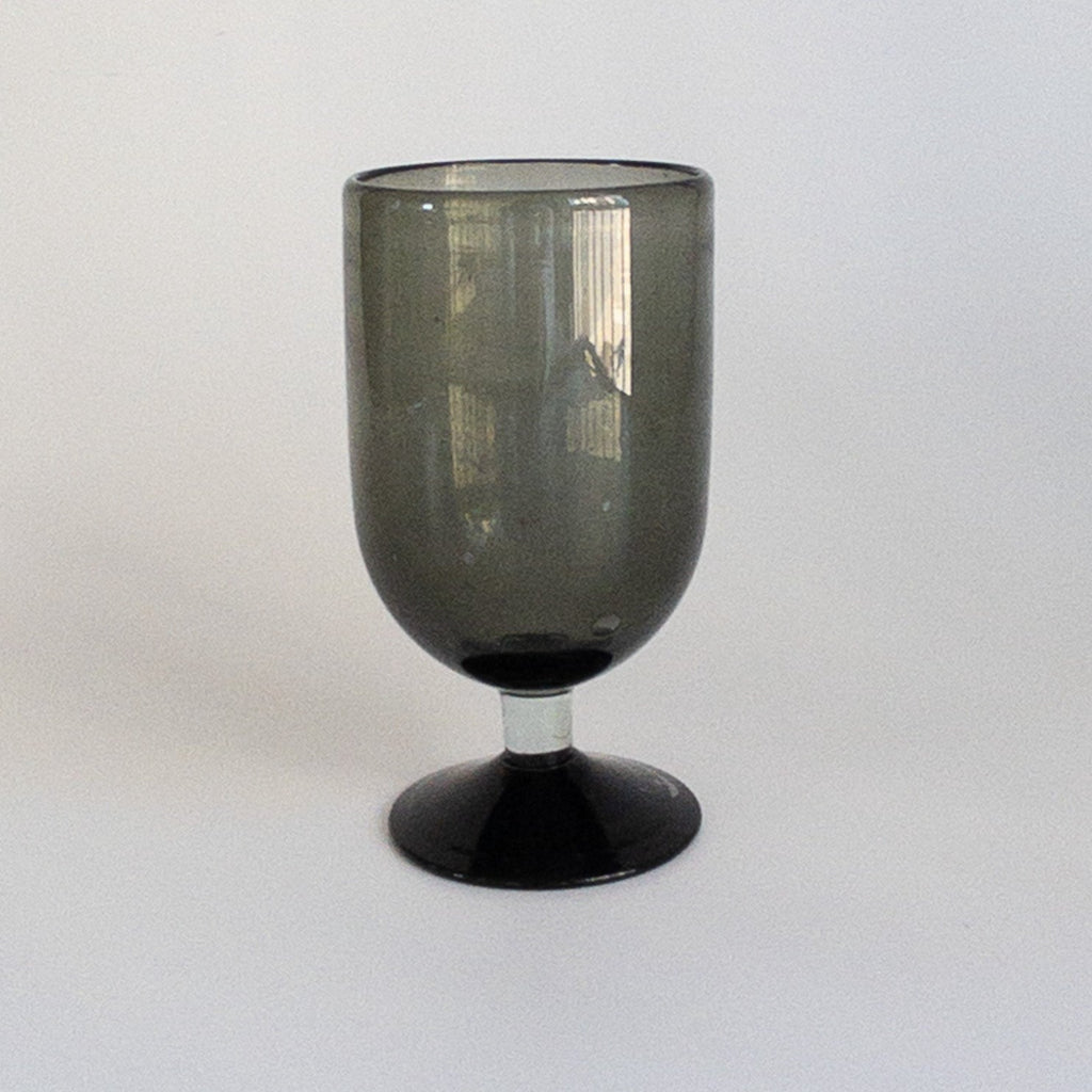 Studio CM | handblown black glass goblet that has a dark base and clear stem