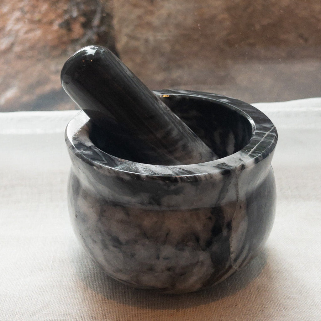 Studio CM | a large mortar and pestle made of black marble