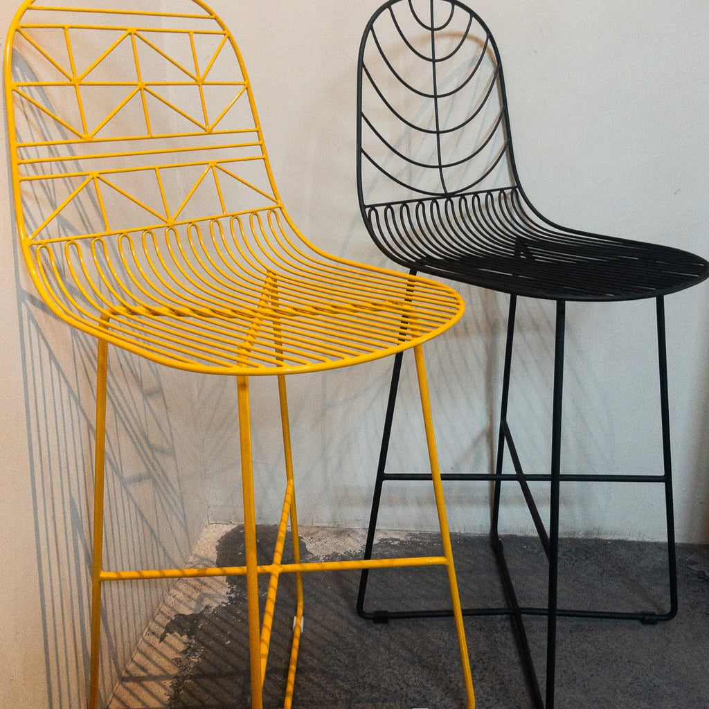 Studio CM | two modern yellow and black rod iron stools with a light and delicate pattern