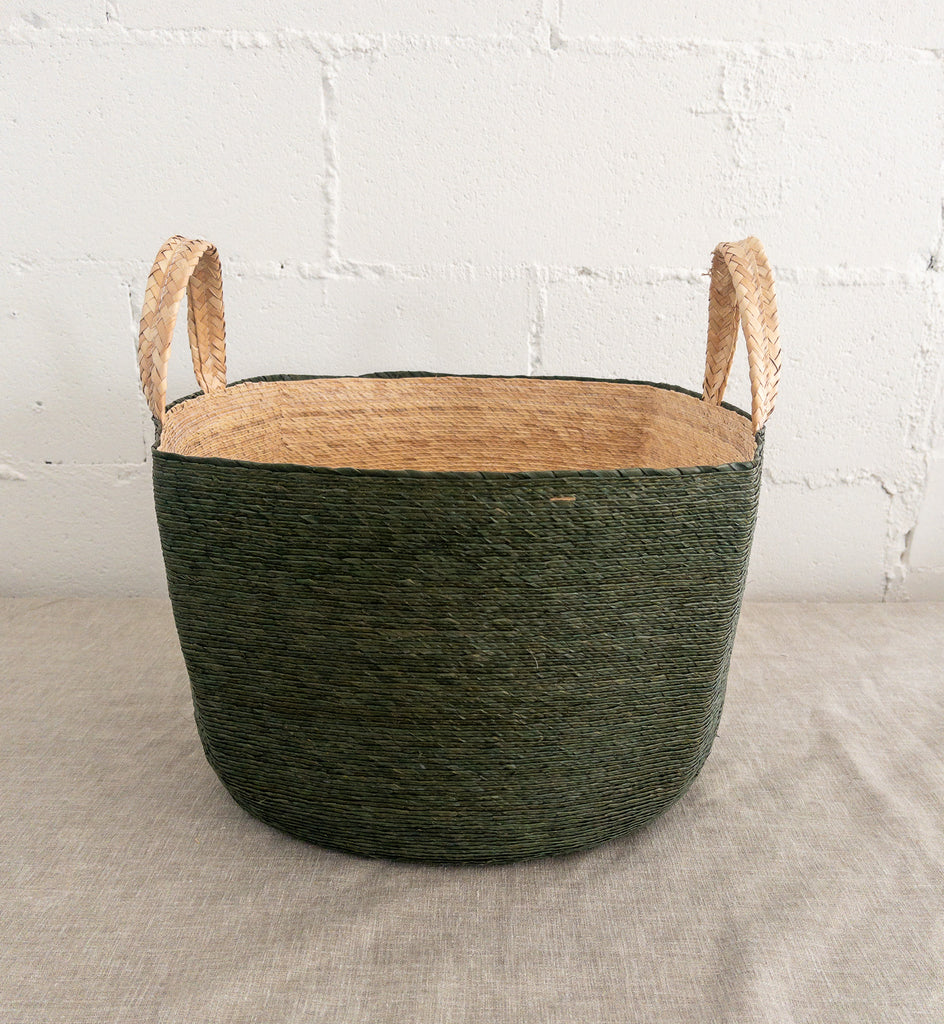 Studio CM | a palm basket that is made of all natural materials that has handles, a green exterior and generous size