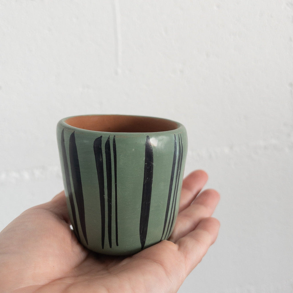 Studio CM | A teal ceramic cup that has hand painted designs in black ink made in Michoacan, Mexico