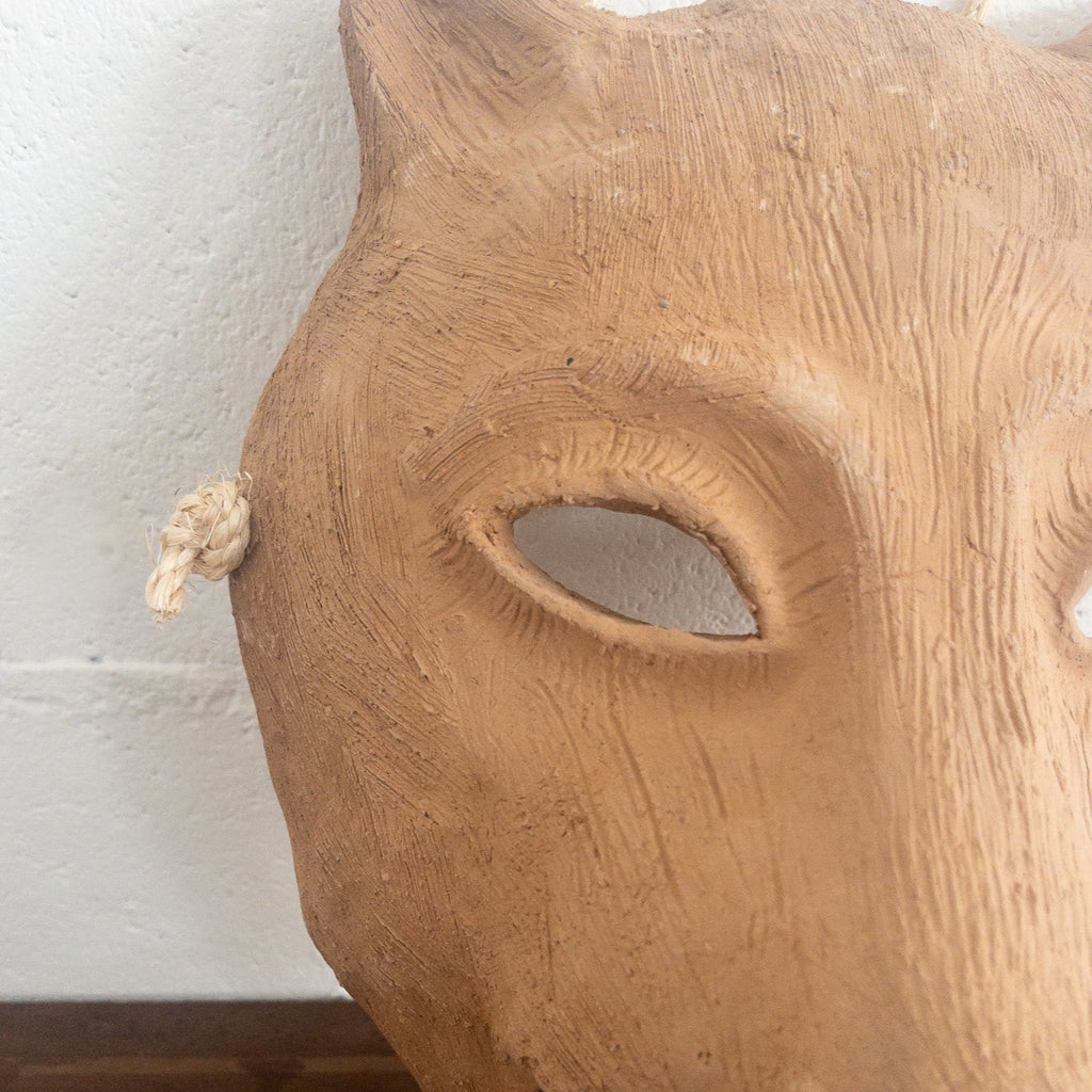 Studio CM | A ceramic mask in the shape of a wolf face made in terracotta colored clay with a role for mounting. Made in Oaxaca, Mexico. 