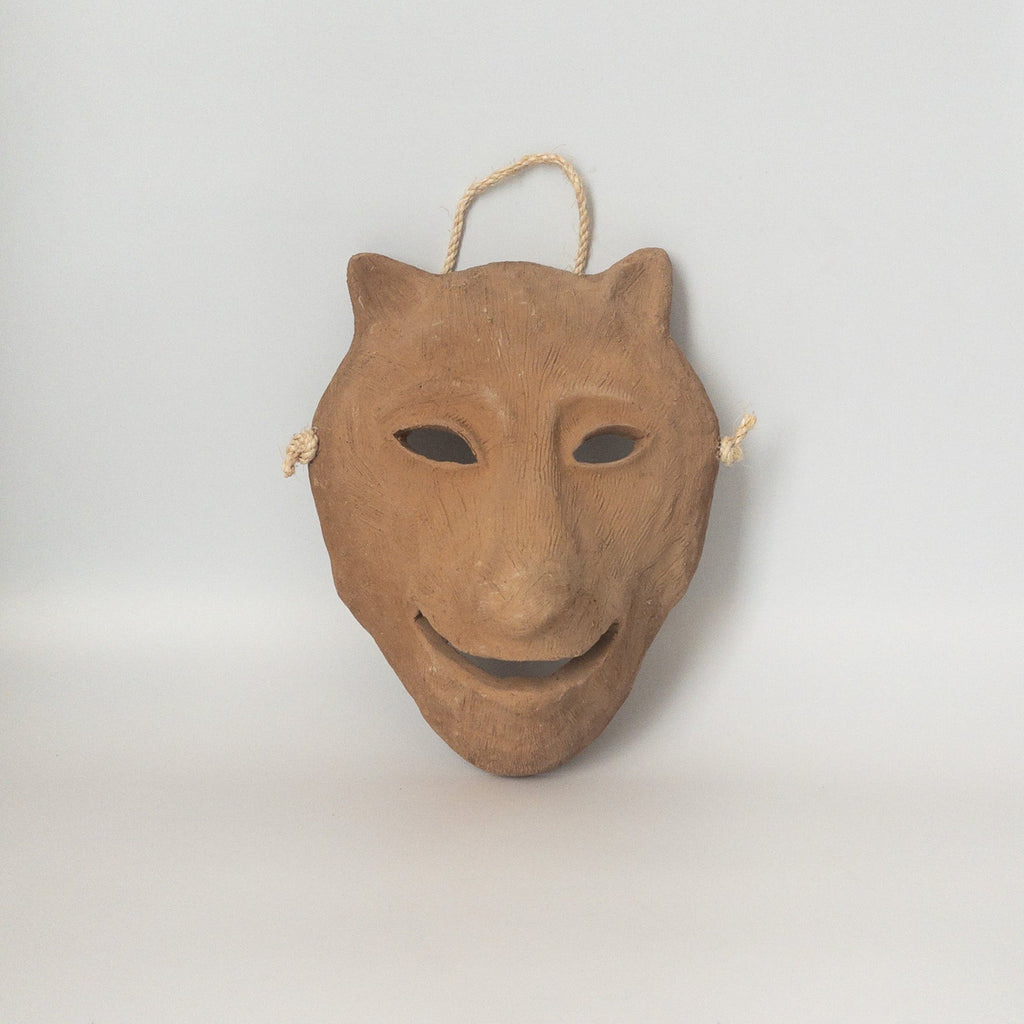 Studio CM | A ceramic mask in the shape of a wolf face made in terracotta colored clay with a role for mounting. Made in Oaxaca, Mexico. 