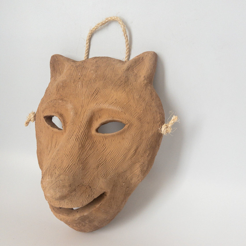 Studio CM | A ceramic mask in the shape of a wolf face made in terracotta colored clay with a role for mounting. Made in Oaxaca, Mexico. 