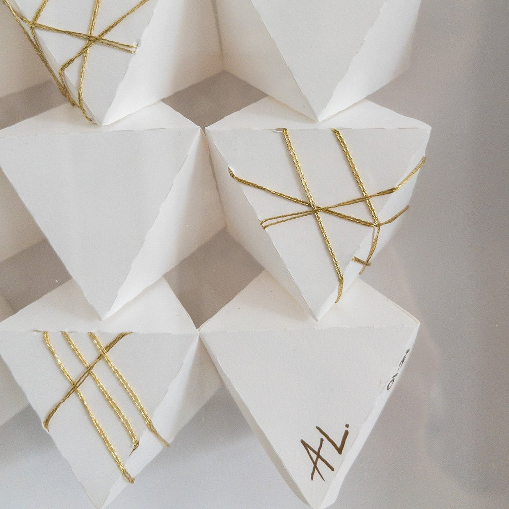 Studio CM | A hand made origami composition with a white monochromatic finish with a gold detail. Made my artist Alicia Lopez.