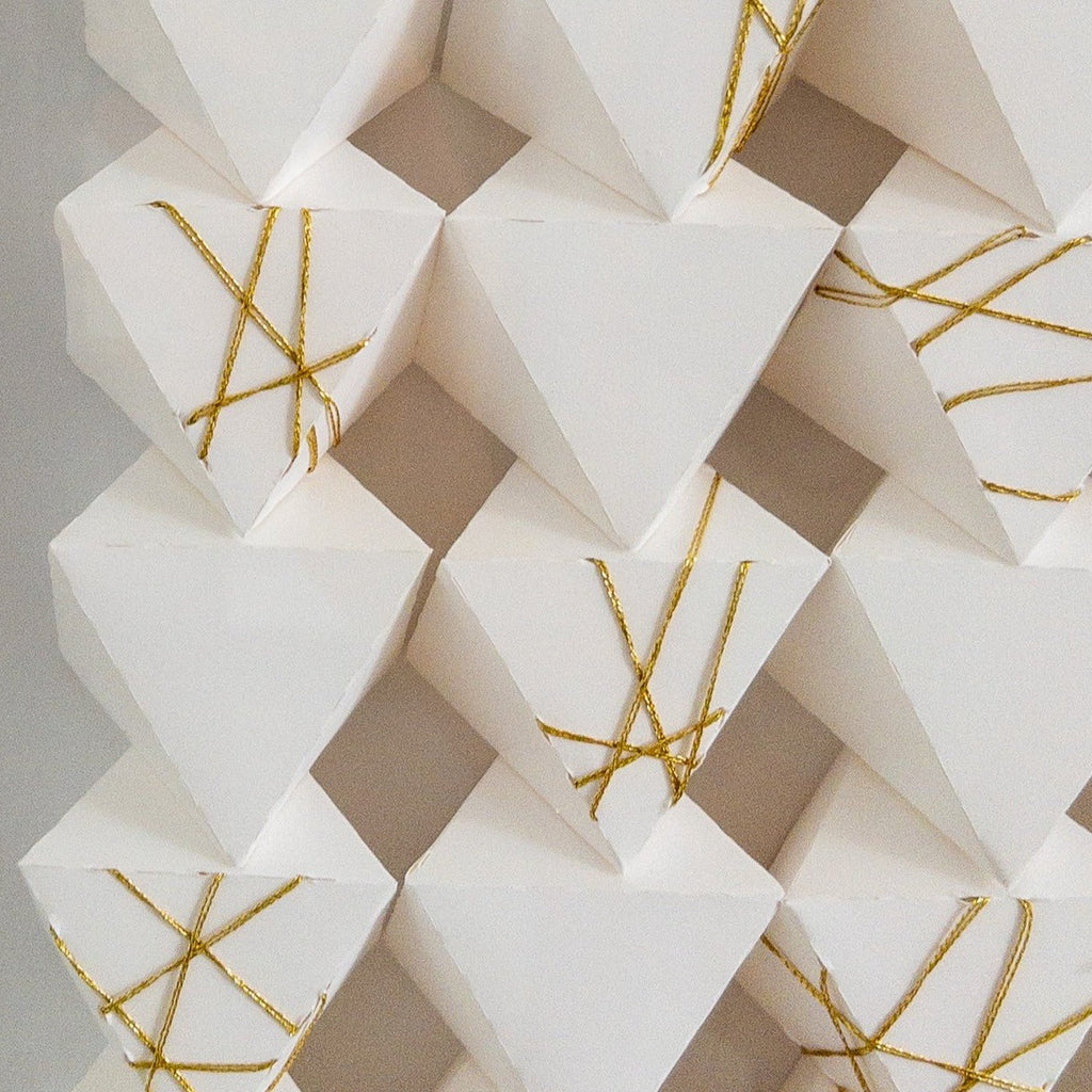 Studio CM | A hand made origami composition with a white monochromatic finish with a gold detail. Made my artist Alicia Lopez.