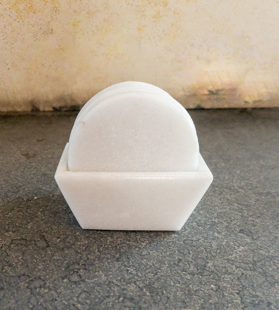 Studio CM | a set of white hand carved marble coasters in a round shape