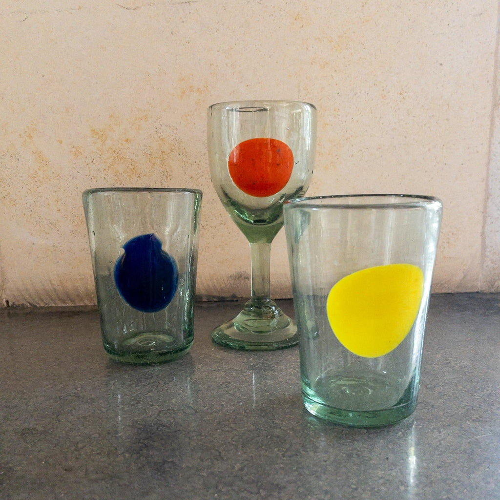 Studio CM | A stemmed glass hand blown from recycled glass that has an orange dot design made in Mexico