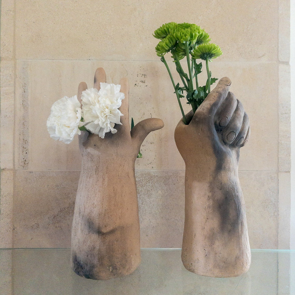 Studio CM | a sculpture that serves as a vase hand made from ceramic that is in the shape of a hand grasping flowers