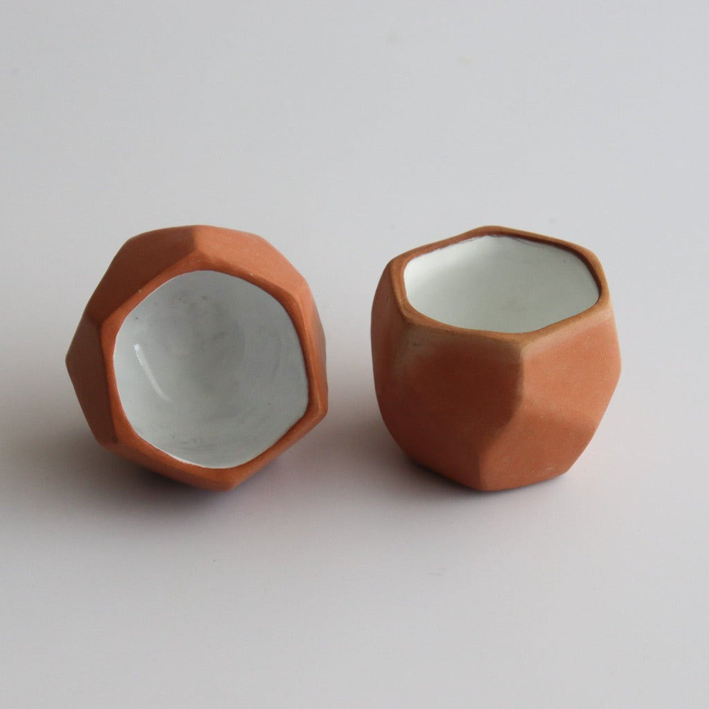 two geometric shot glasses made of ceramic with an interior white glaze