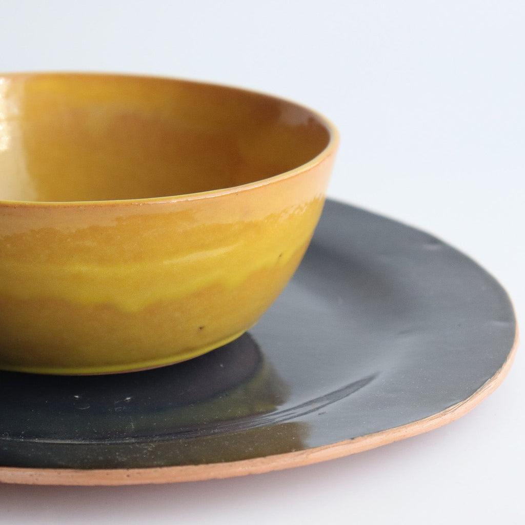 Studio CM | Ceramic plates made of clay by hand in Merida Mexico. They have an uncured bottom exposed which is terracotta color and the top is a navy blue glaze.