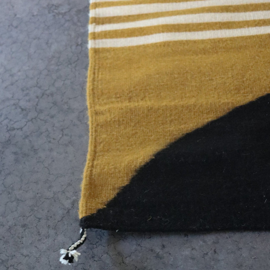 Studio CM | a yellow, cream and black handmade rug from Oaxaca. It is made by Zapotec 10th generation artisans. The rug is 100% natural materials.