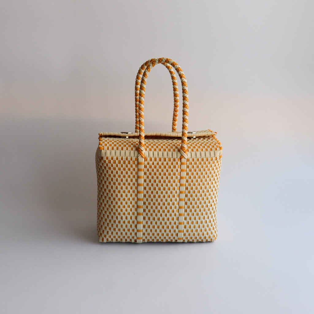 Studio CM | A hand woven silver plastic reusable purse. It is woven together with individual strands, held together by magnetic buttons and has two straps.