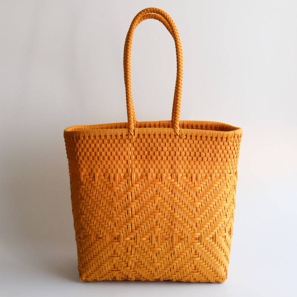 Studio CM | A handwoven plastic tote that is a rich mustard yellow made in Jalisco, Mexico