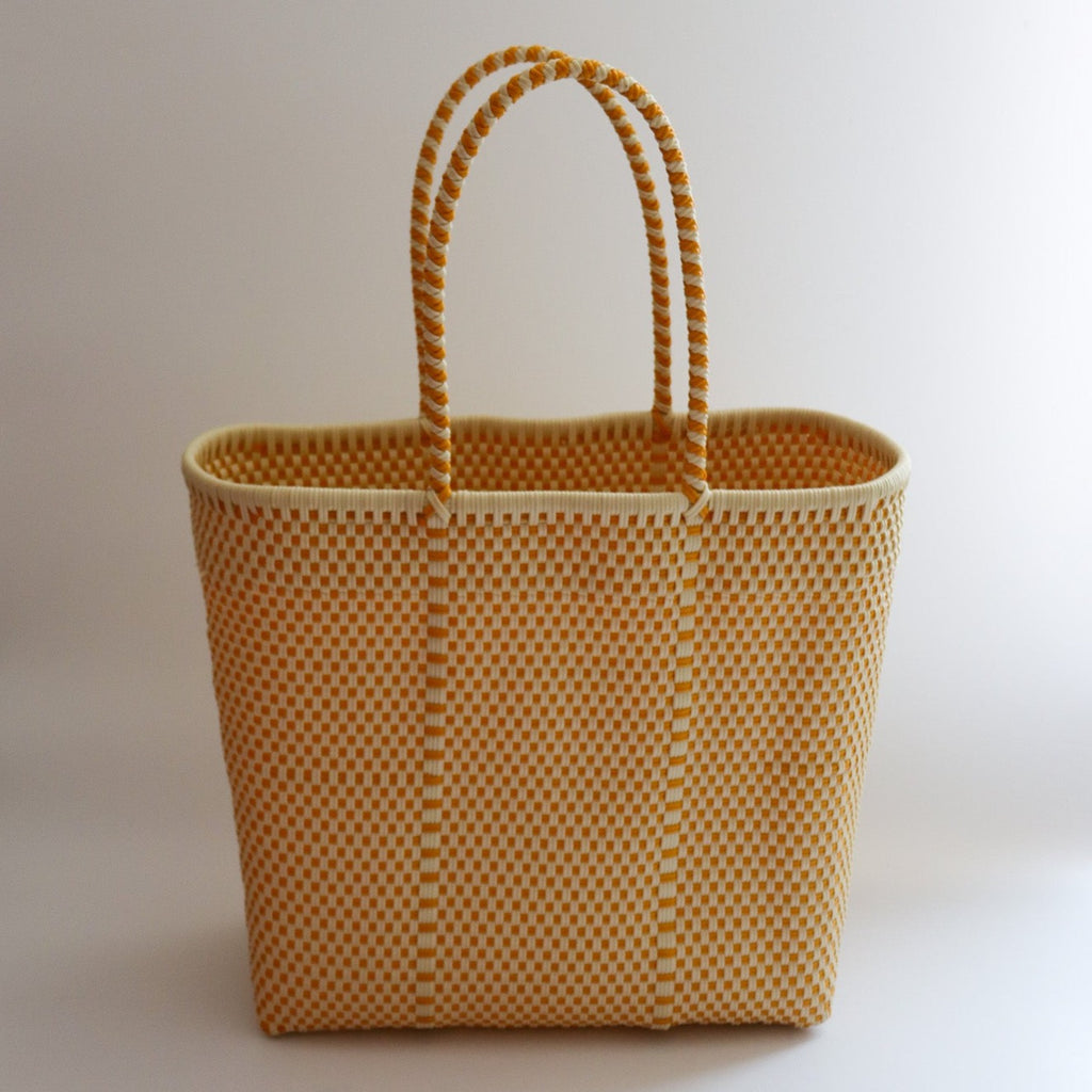 Studio CM | A large handwoven plastic tote that is a yellow and white made in Jalisco, Mexico