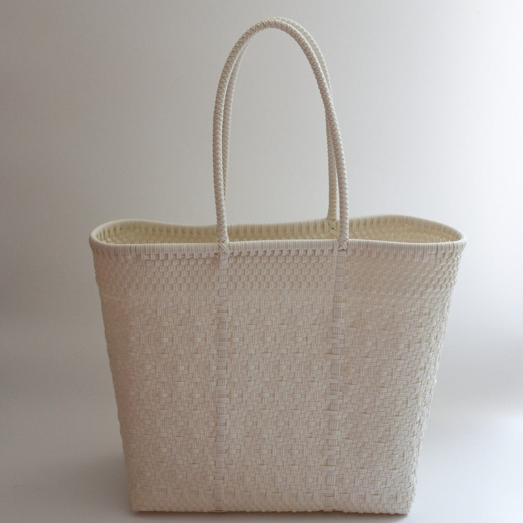 Studio CM | A handmade purse from Jalisco, MX that is woven by white plastic strands. It is a large tote that can be used for the beach or travel due to being highly resistant.