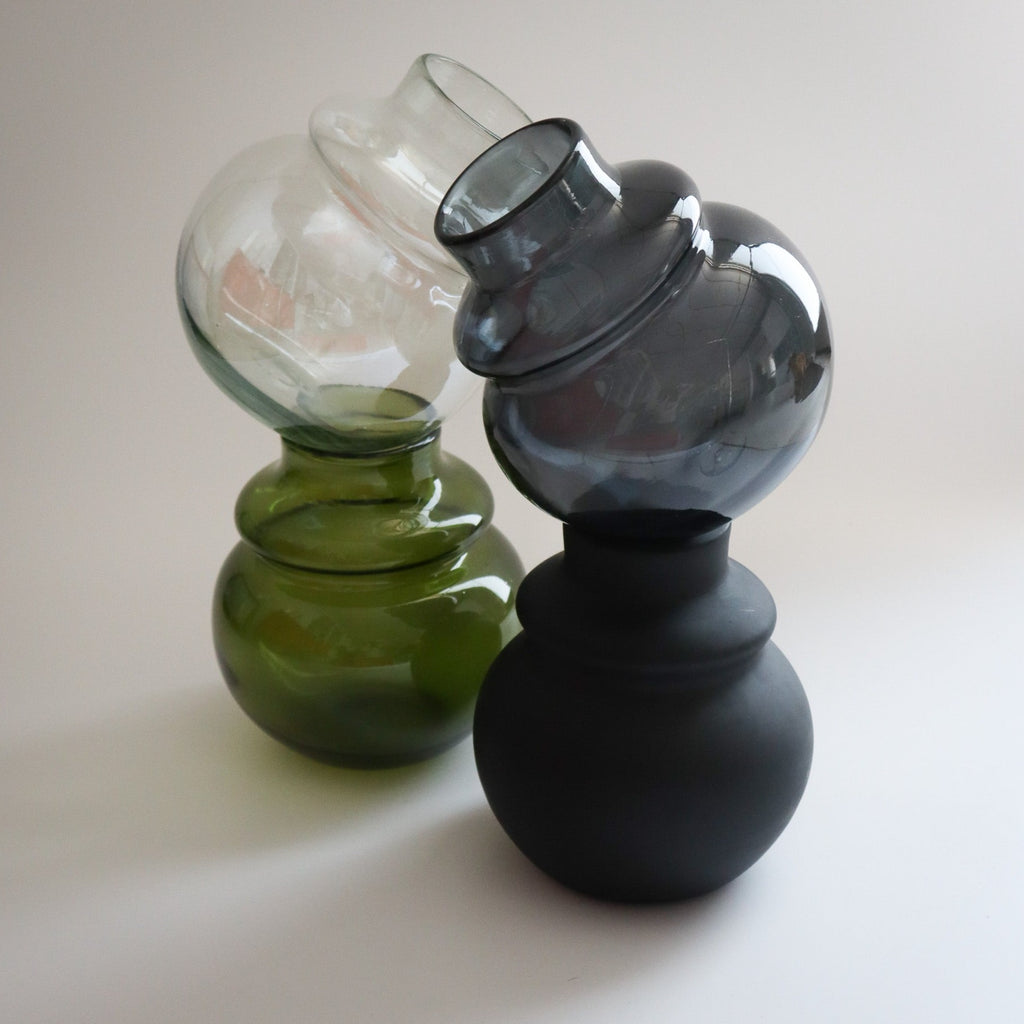 Studio CM | four glass vases in the same round shape in green, clear, black and matte black stacked on top of each other. They are hand blown in Jalisco, Mexico