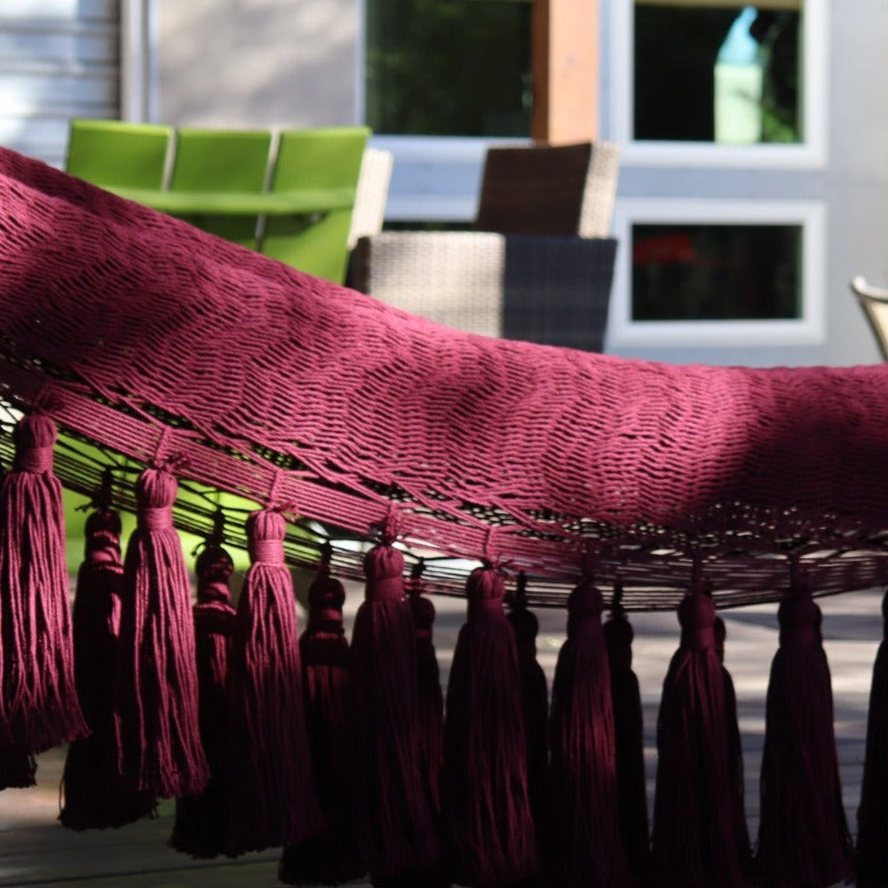 Studio CM | a burgundy cotton hammock with pom poms that is handmade in Merida Mexico from cotton and natural dyes