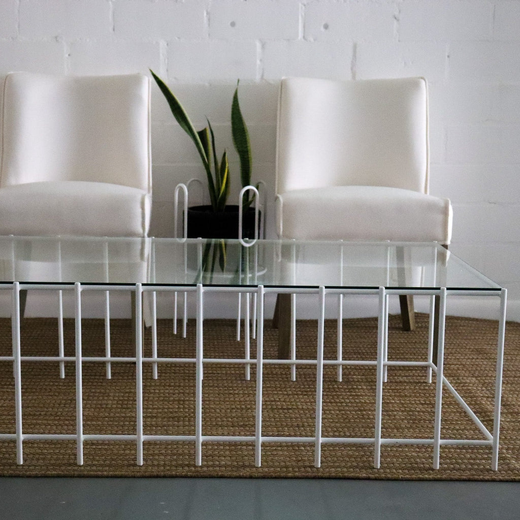 Studio CM | a modern rod iron coffee table that is made with metal parallel legs and a tempered glass top to size. The product is welded in Guadalajara Mexico