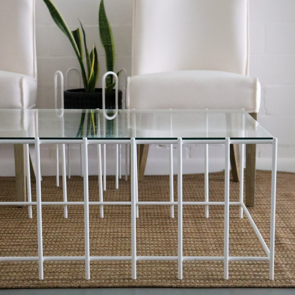 Studio CM | a modern rod iron coffee table that is made with metal parallel legs and a tempered glass top to size. The product is welded in Guadalajara Mexico