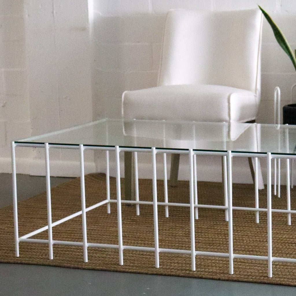 Studio CM | a modern rod iron coffee table that is made with metal parallel legs and a tempered glass top to size. The product is welded in Guadalajara Mexico