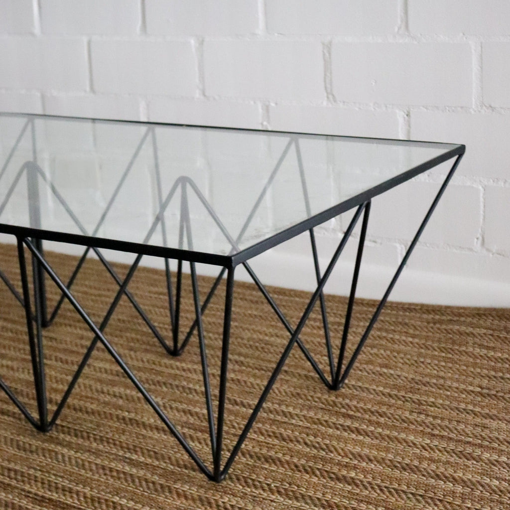 Studio CM | a modern rod iron coffee table that is made with metal triangular legs and a tempered glass top to size. The product is welded in Guadalajara Mexico