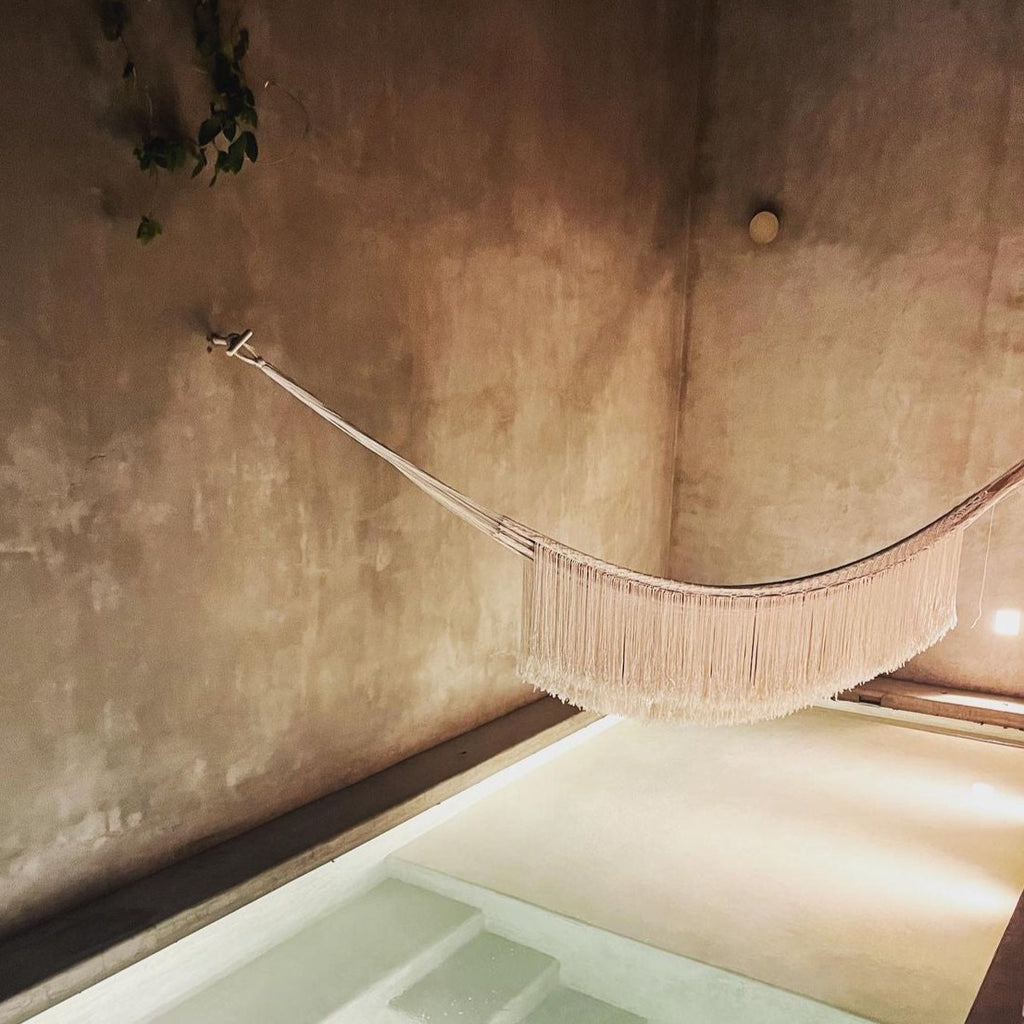 Studio CM | A silver hammock hanging above a pool in a relaxing scene