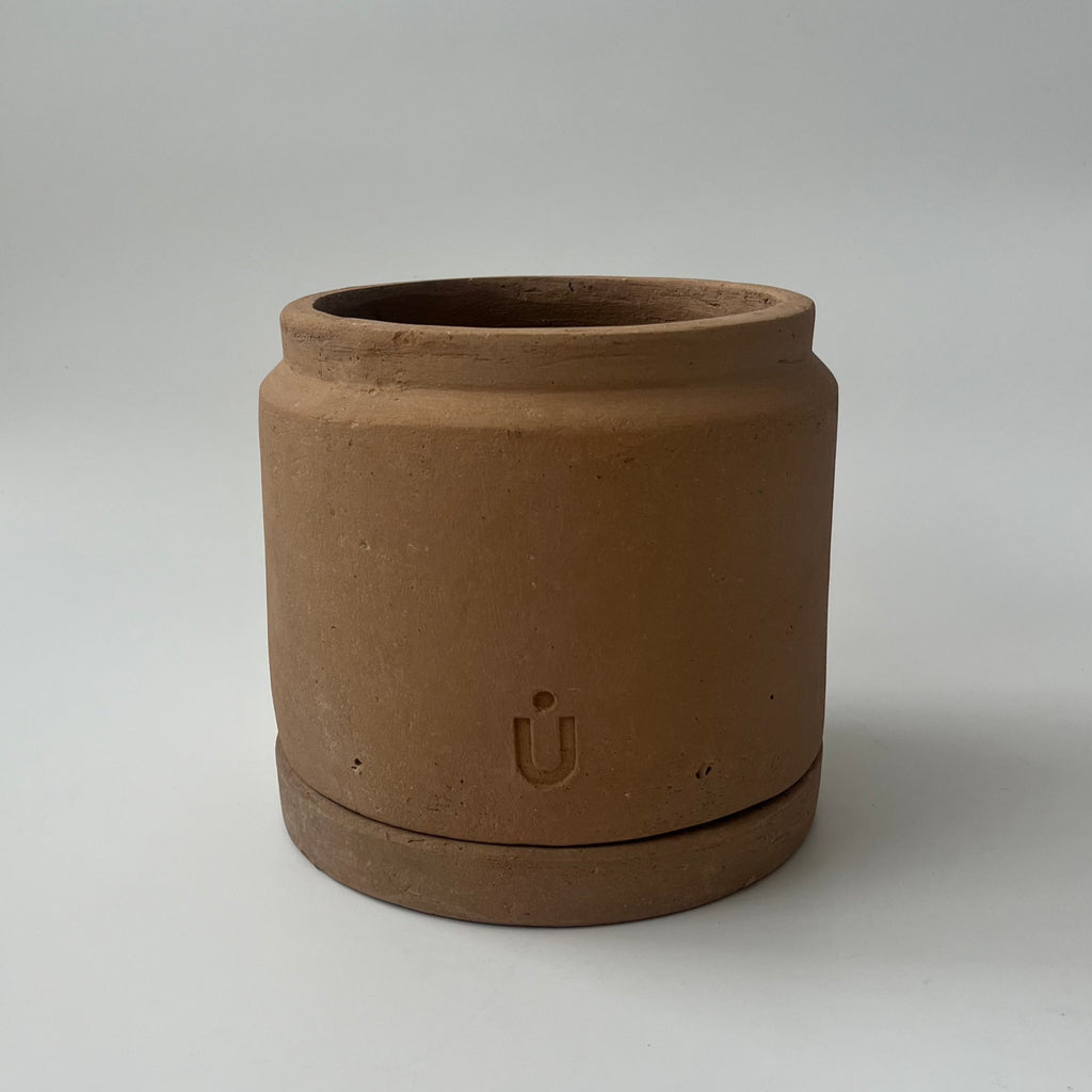 Studio CM | A short cylindrical and modern planter made of terracotta that comes with it's matching dish