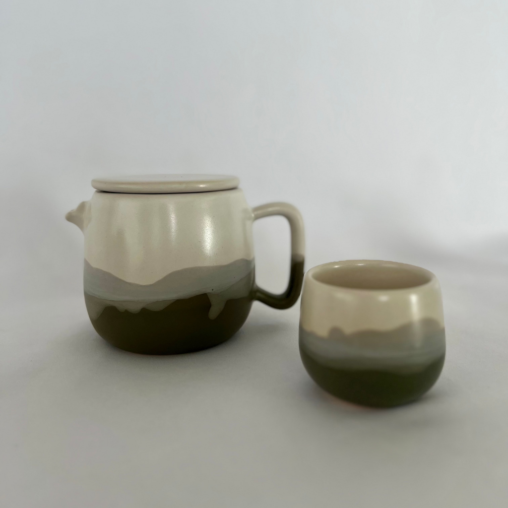 Studio CM | A ceramic tea cup with a beautiful multicolored glaze that is part of a larger set