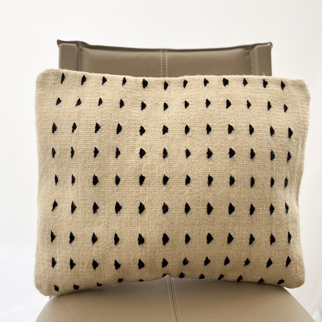 Studio CM | A cream colored wool pillowcase that has black dots made in Oaxaca Mexico by hand