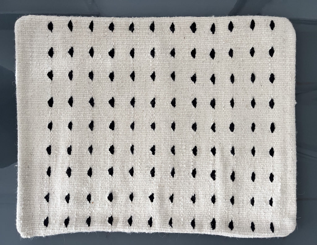 Studio CM | A cream colored wool pillowcase that has black dots made in Oaxaca Mexico by hand