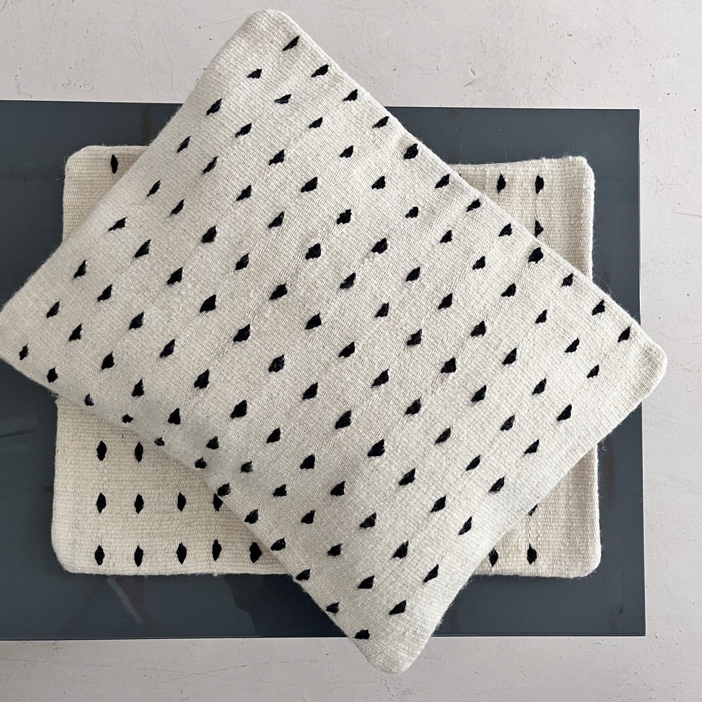 Studio CM | A cream colored wool pillowcase that has black dots made in Oaxaca Mexico by hand