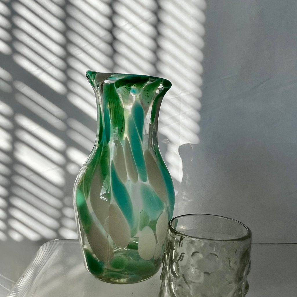 Studio CM | A carafe with a blend of pastel colors that has an hourglass shape. Handblown in Jalisco from recycled glass. 