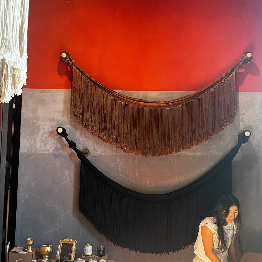 Studio CM | two hammocks hanging on a wall that are brown and black