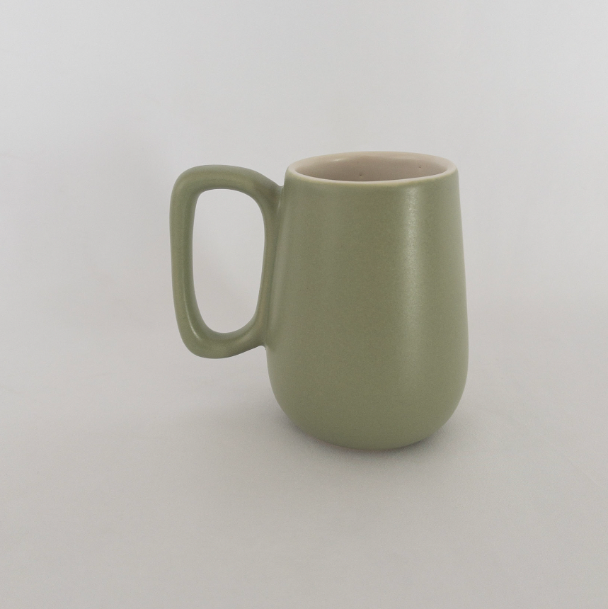 Studio CM | A handmade ceramic mug that has a lovely green color on the outside and white ceramic inside