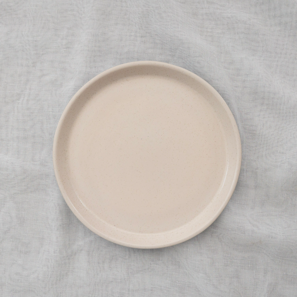 Studio CM | A two tone ceramic plate with a cream speckled surface and light blue base