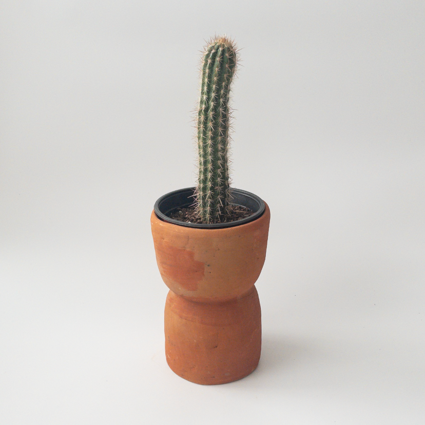 Studio CM | A terracotta colored ceramic planter that is handmade in Oaxaca with an hourglass shape with a drainage hole