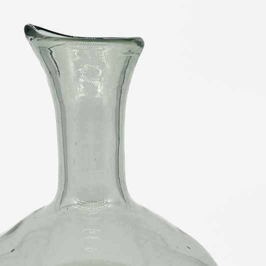 Studio CM | A white and clear carafe with a round bottom and pour built into the mouth made of handblown glass in Jalisco, Mexico