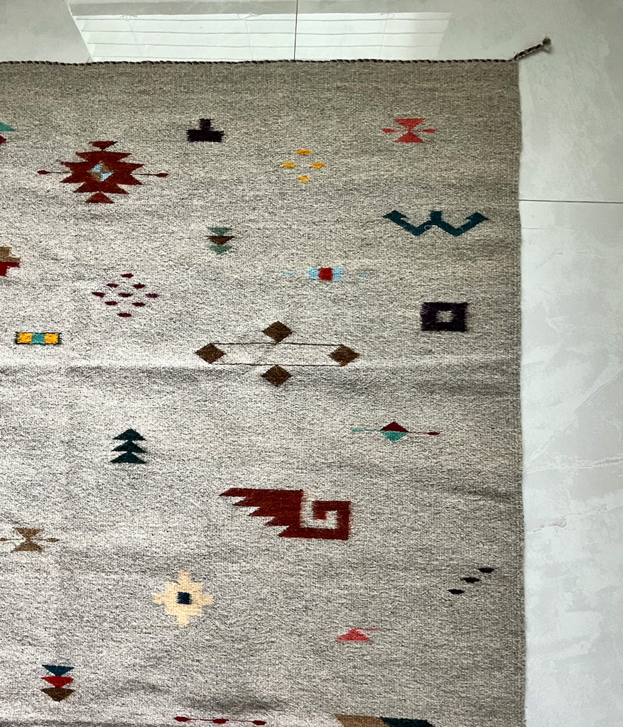 Studio CM | A cream rug with traditional Zapotec shapes that are multicolor handwoven wool from Oaxaca Mexico