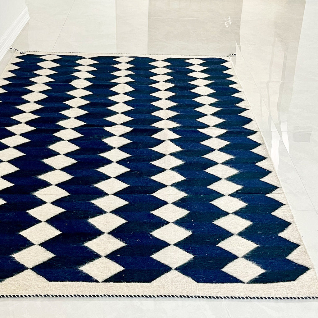 Studio CM | A wool handwoven rug from Oaxaca that was made with natural dyes and materials with a blue, navy and cream geometric pattern