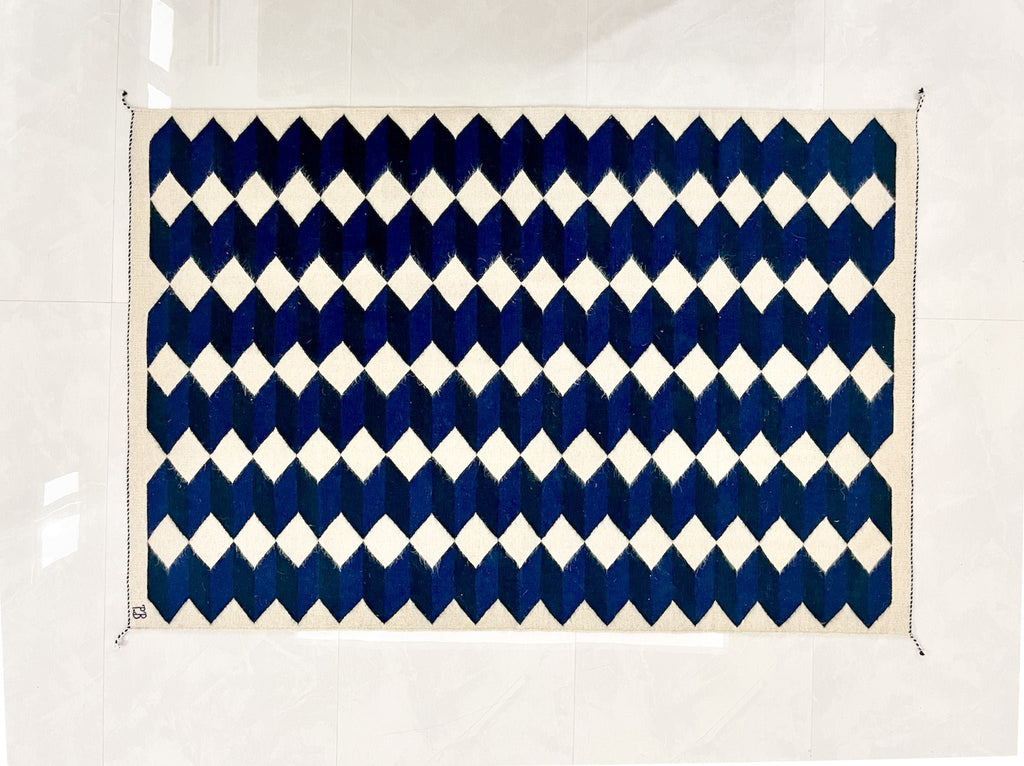 Studio CM | A wool handwoven rug from Oaxaca that was made with natural dyes and materials with a blue, navy and cream geometric pattern