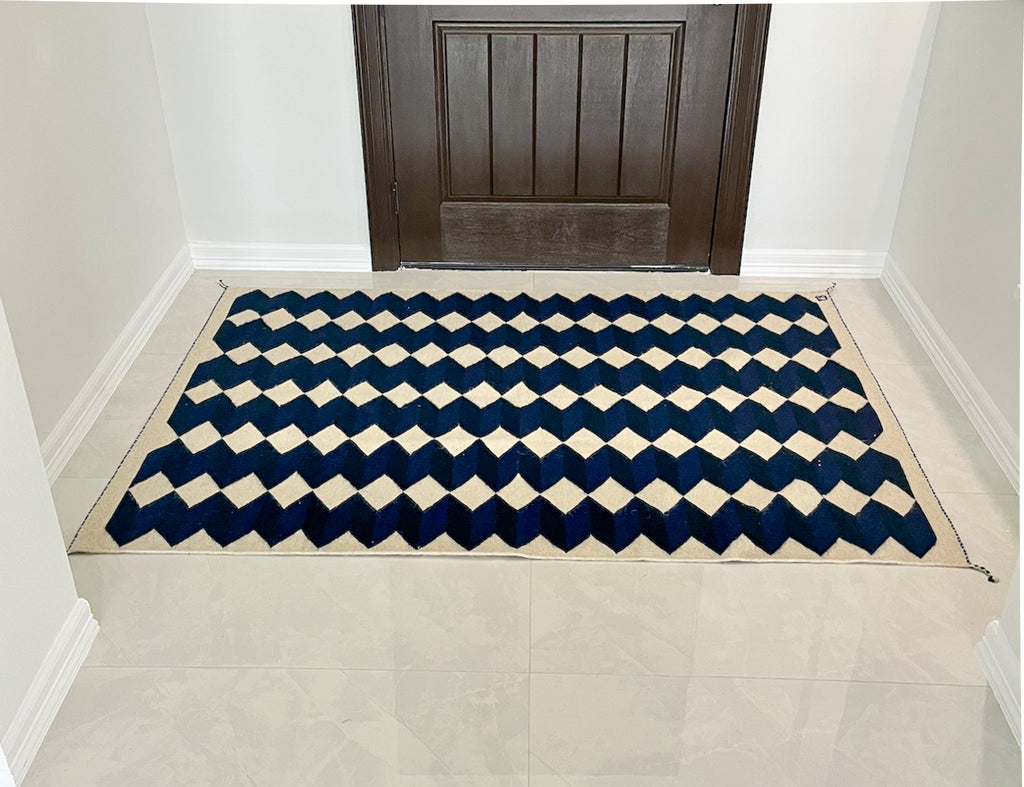 Studio CM | A wool handwoven rug from Oaxaca that was made with natural dyes and materials with a blue, navy and cream geometric pattern