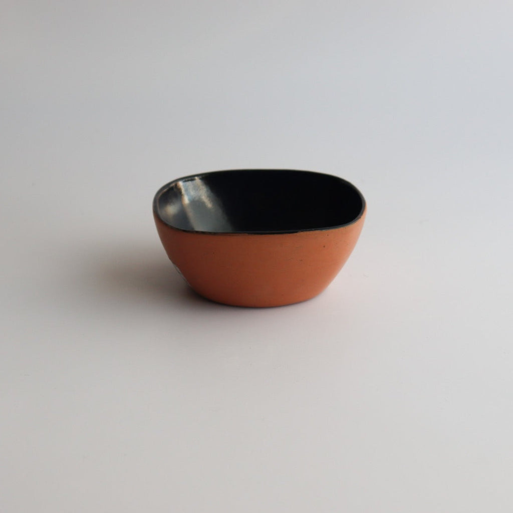 Studio CM | ceramic bowl with a natural clay exterior and blue glazed interior with a white background