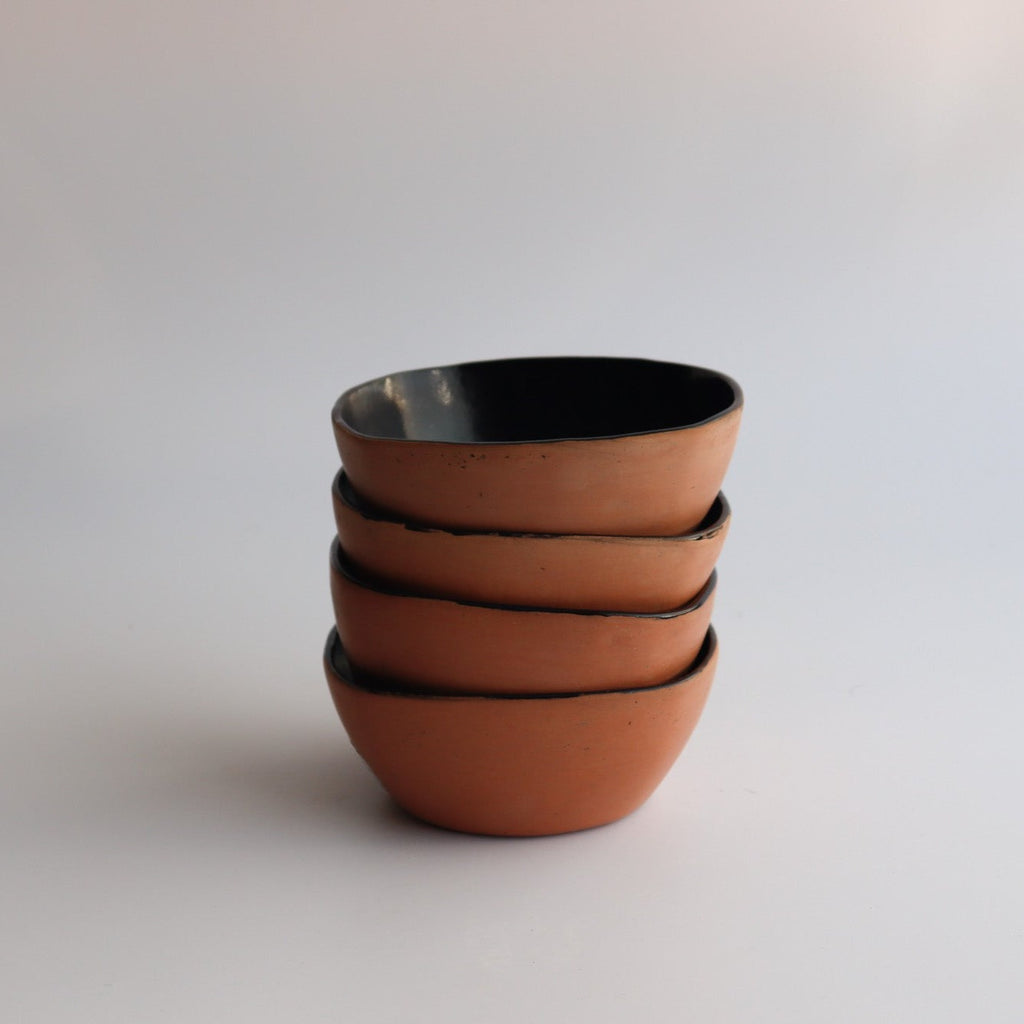 Studio CM | four ceramic bowl with a natural clay exterior stacked on top of each other with a white background