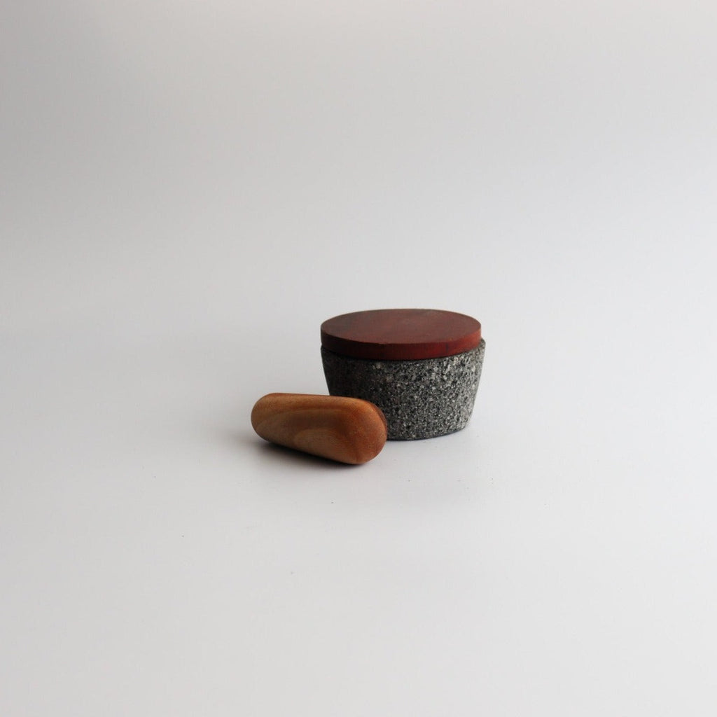 Studio CM | a small hand carved volcanic stone mortar with a wooden top and pestle